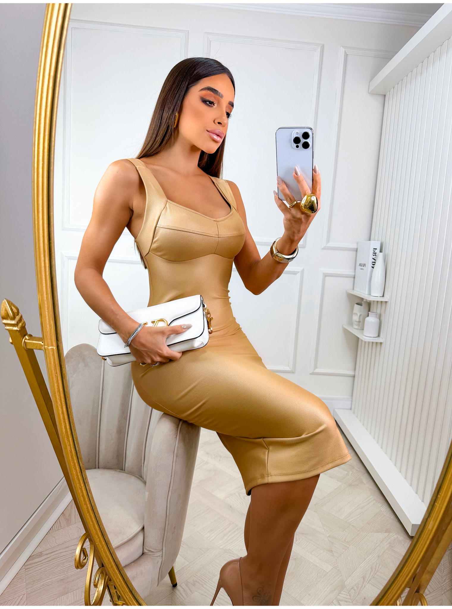 Mujer tomándose una selfie con el vestido Amara dorado frente a un espejo
