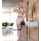 Mujer con vestido midi ajustado Alda, con estampado floral y de leopardo, posando en un elegante interior.